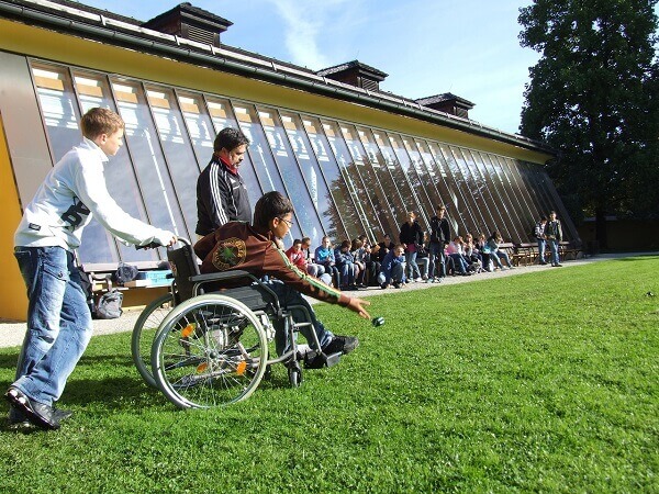 Kind im Rollstuhl nimmt am Schulalltag teil