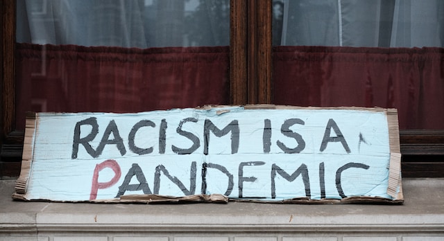 Schild mit der Aufschrift: Racism is a pandemic