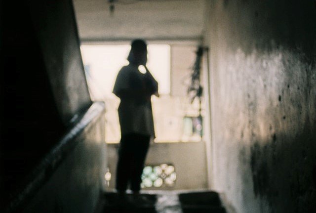 Silhouette einer weiblich gelesenen Person in einem Treppenhaus