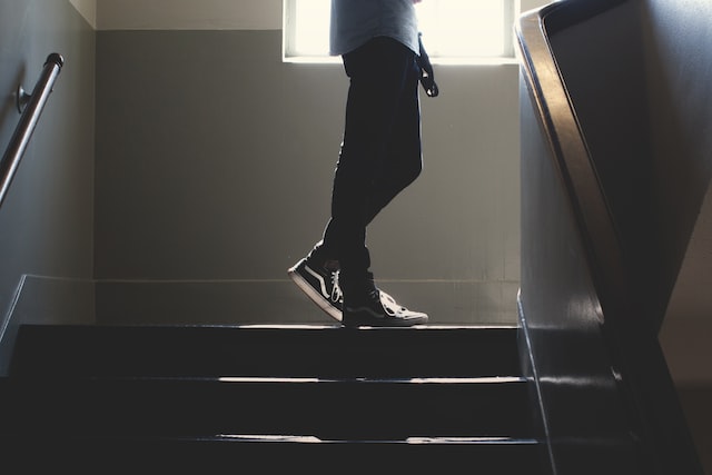 Person steht auf schwach beleuchteter Treppe