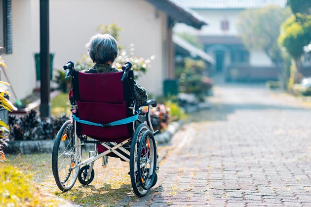 Ältere Person alleine im Rollstuhl
