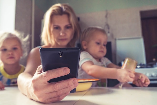 Mutter mit zwei Kindern am Smartphone